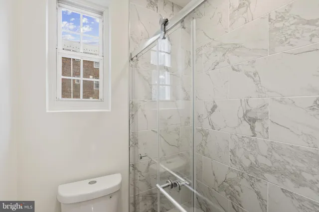 a bathroom with a toilet and a shower