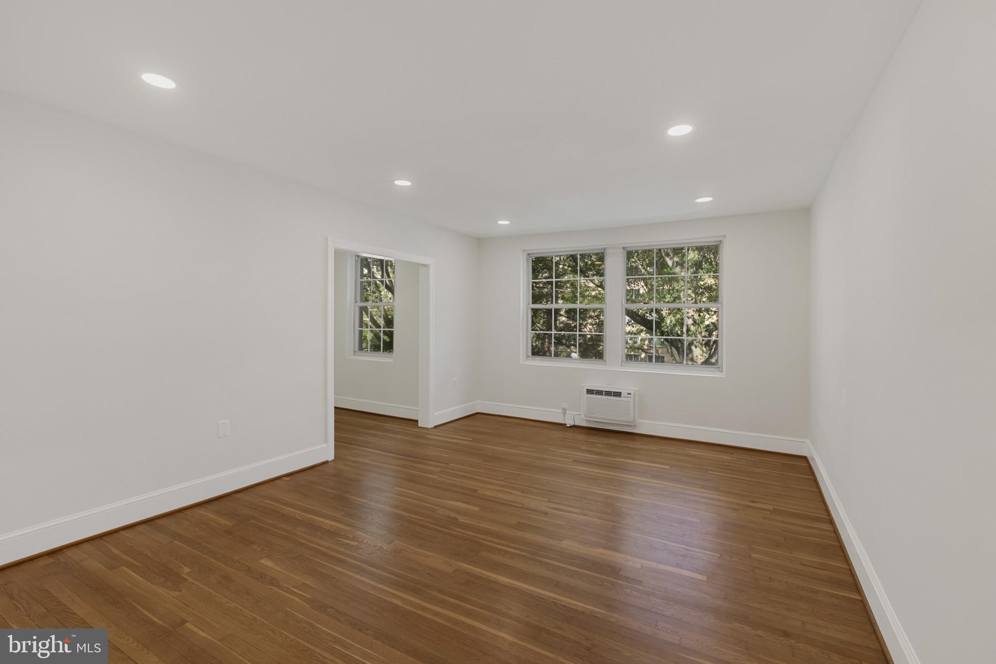 3051 Idaho Avenue Northwest, Unit 204 Washington, DC 20016 - Photo 4 of 27 an empty room with wooden floor and windows