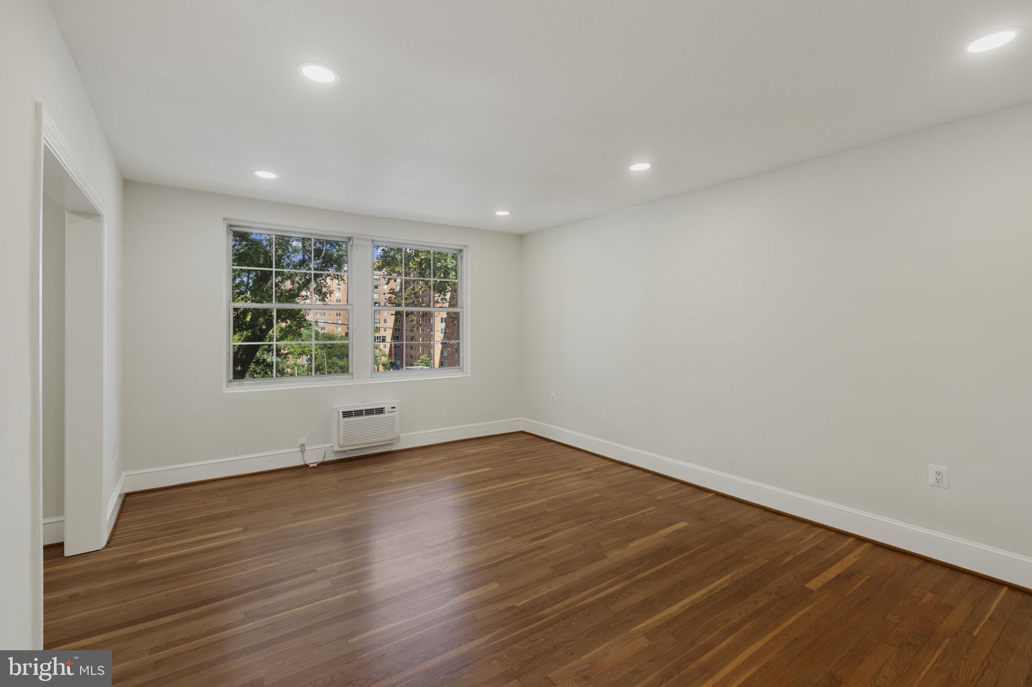 3051 Idaho Avenue Northwest, Unit 204 Washington, DC 20016 - Photo 5 of 27 an empty room with wooden floor and windows
