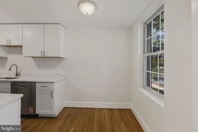 a view of a kitchen with cabinets and wooden floor