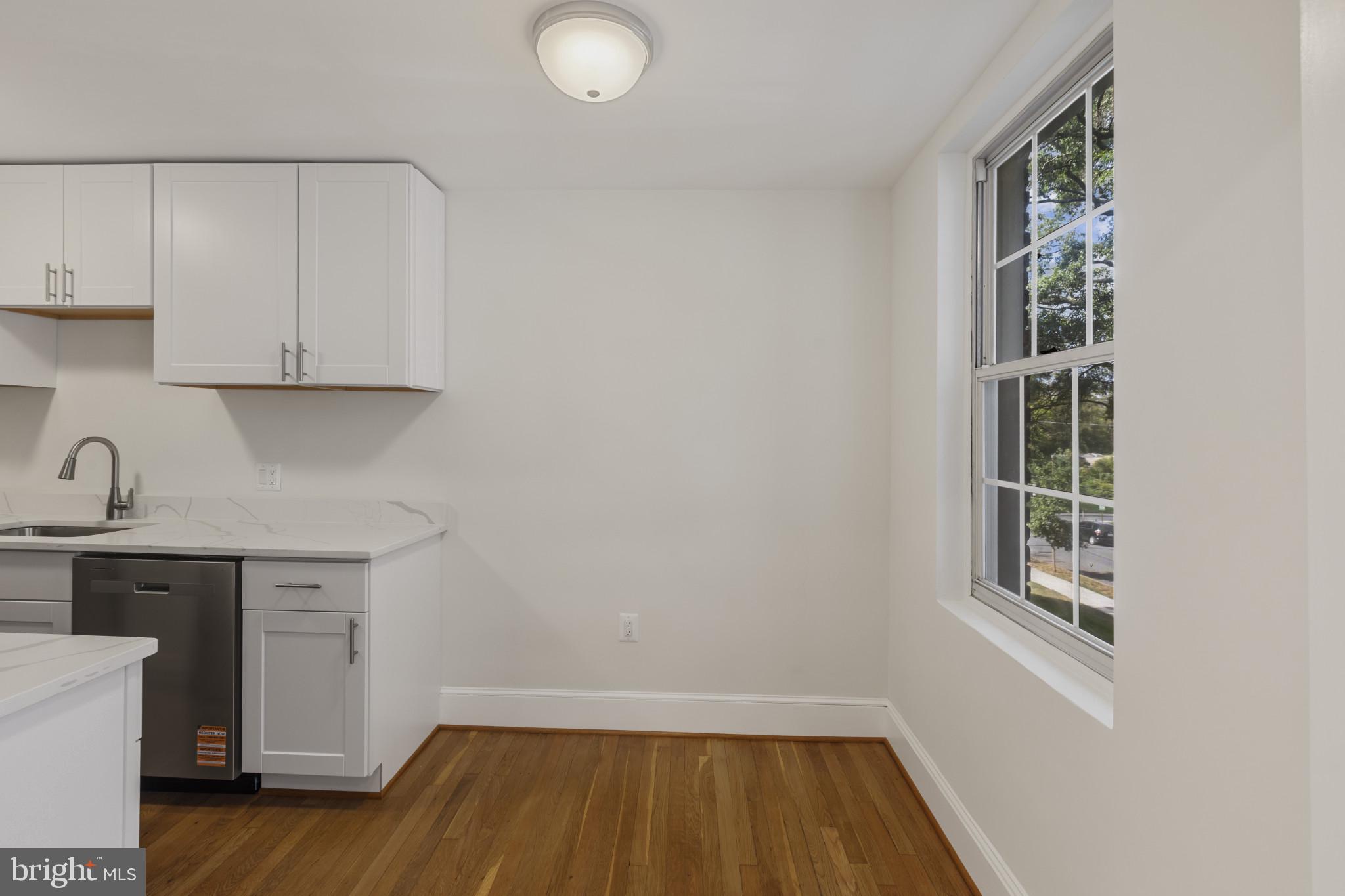 3051 Idaho Avenue Northwest, Unit 204 Washington, DC 20016 - Photo 8 of 27 a view of a kitchen with cabinets and wooden floor