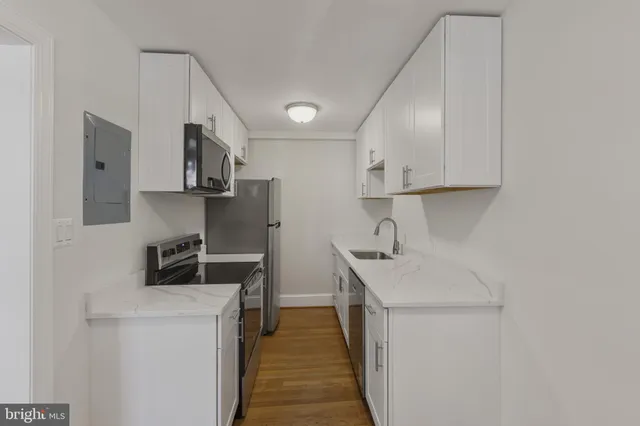 a kitchen that has a sink a stove and a refrigerator