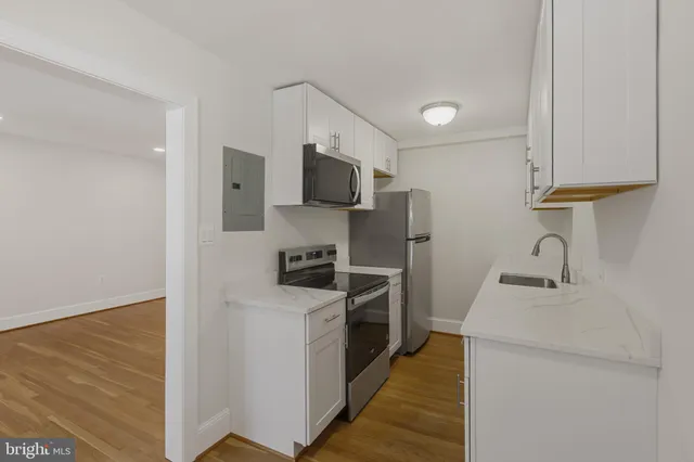 a kitchen with stainless steel appliances a stove microwave and sink