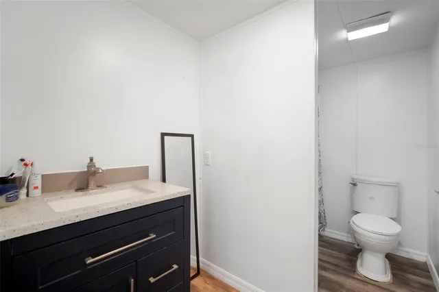 a bathroom with a granite countertop toilet sink and mirror