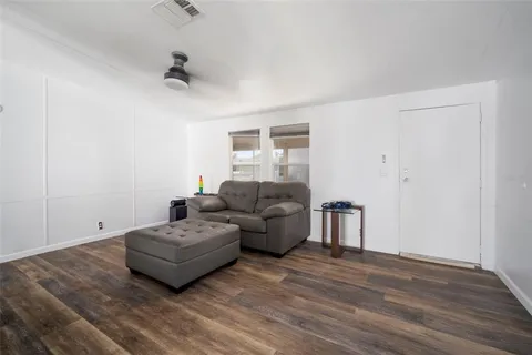 a living room with furniture and a wooden floor