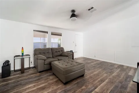 a living room with furniture and a wooden floor