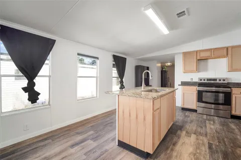 a kitchen with stainless steel appliances granite countertop a stove a sink and a microwave