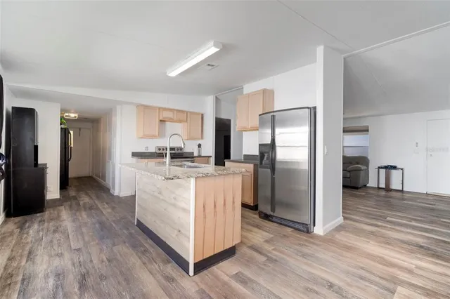 a kitchen with stainless steel appliances granite countertop a refrigerator and a stove top oven