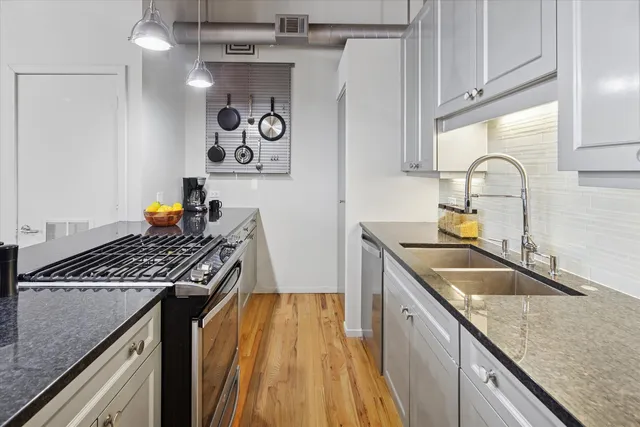 a kitchen with stainless steel appliances granite countertop a sink and a stove