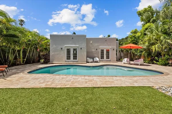 a view of a house with swimming pool and sitting area