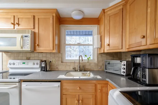 a kitchen with stainless steel appliances granite countertop a sink stove and cabinets