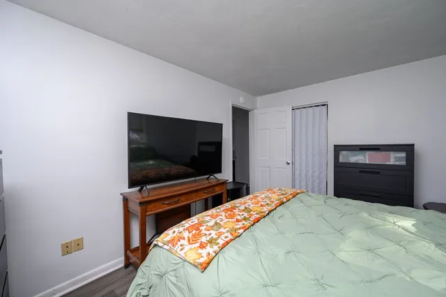 a bedroom with a bed and a flat screen tv