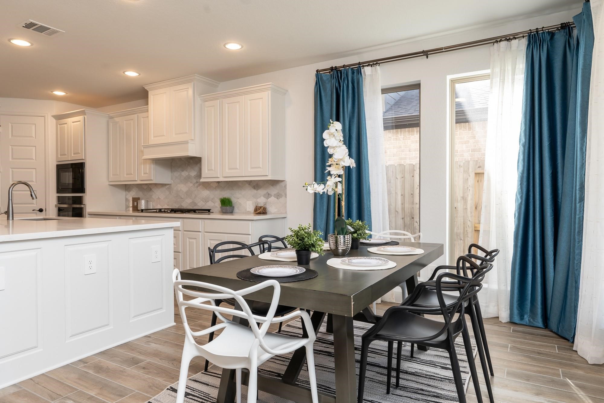 4118 Ana Ridge Lane Fulshear, TX 77441 - Photo 20 of 49 a kitchen with stainless steel appliances granite countertop a table and chairs in it