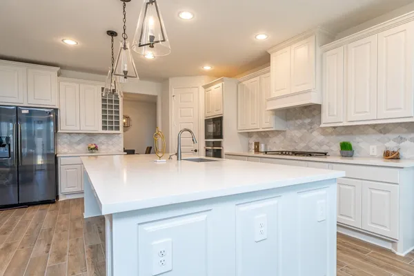 a kitchen with kitchen island a sink stainless steel appliances and cabinets