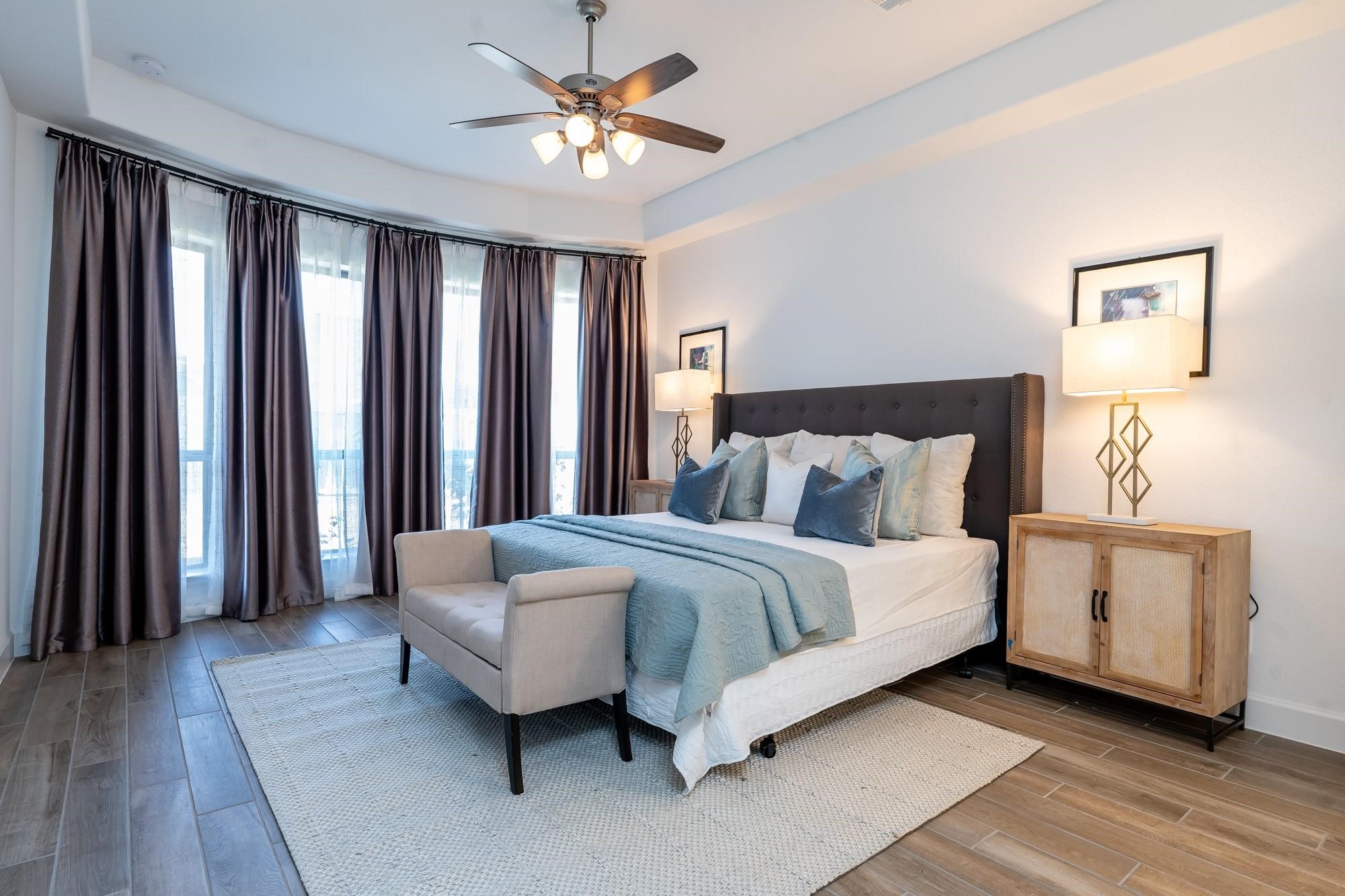 4118 Ana Ridge Lane Fulshear, TX 77441 - Photo 26 of 49 a spacious bedroom with a bed and a chandelier