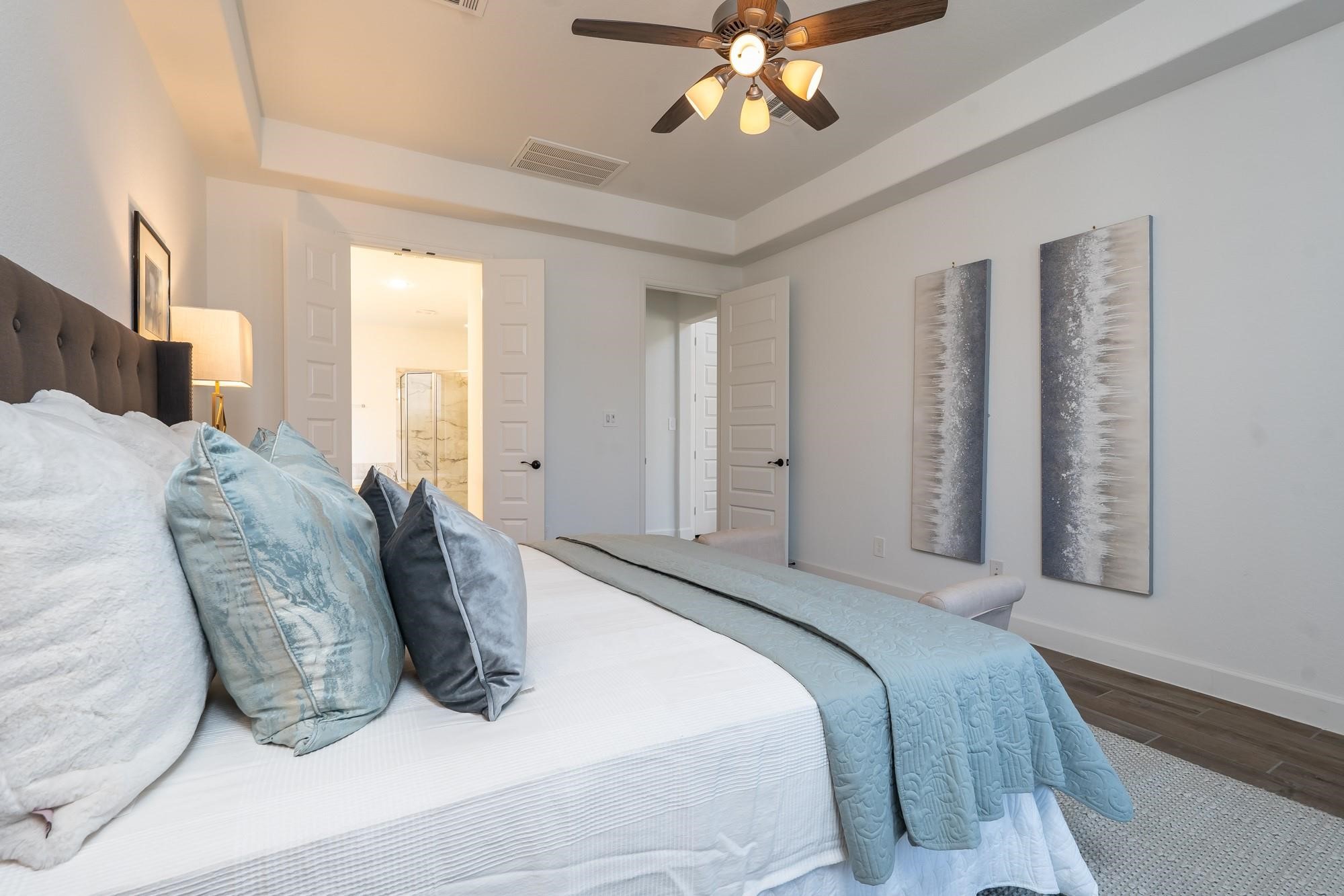 4118 Ana Ridge Lane Fulshear, TX 77441 - Photo 27 of 49 a bedroom with a large bed and a chandelier