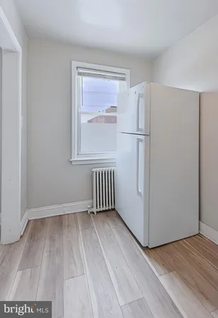 a view of a kitchen with a refrigerator wooden floor and a sink
