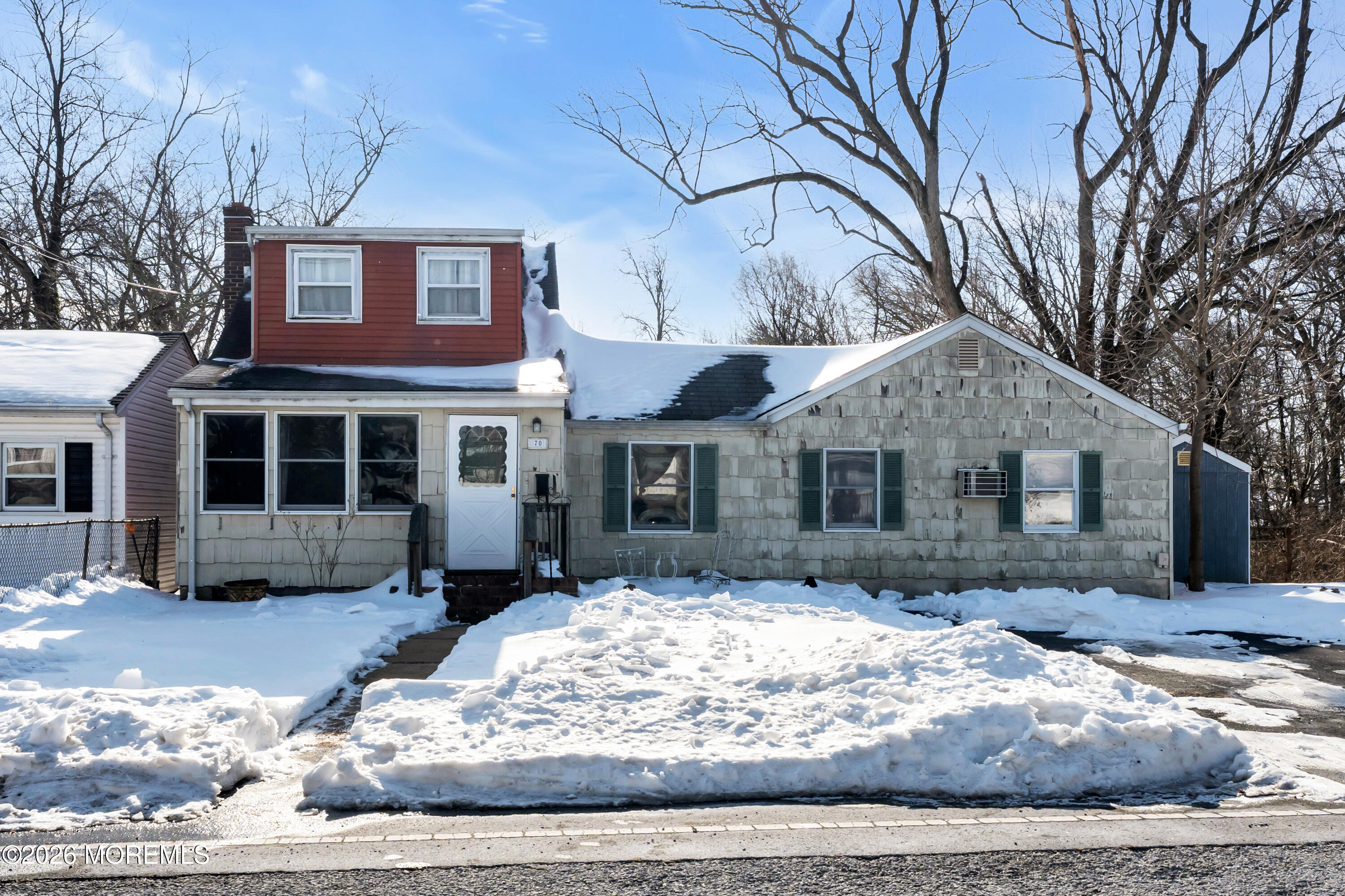 a front view of a house with a yard covered in snow