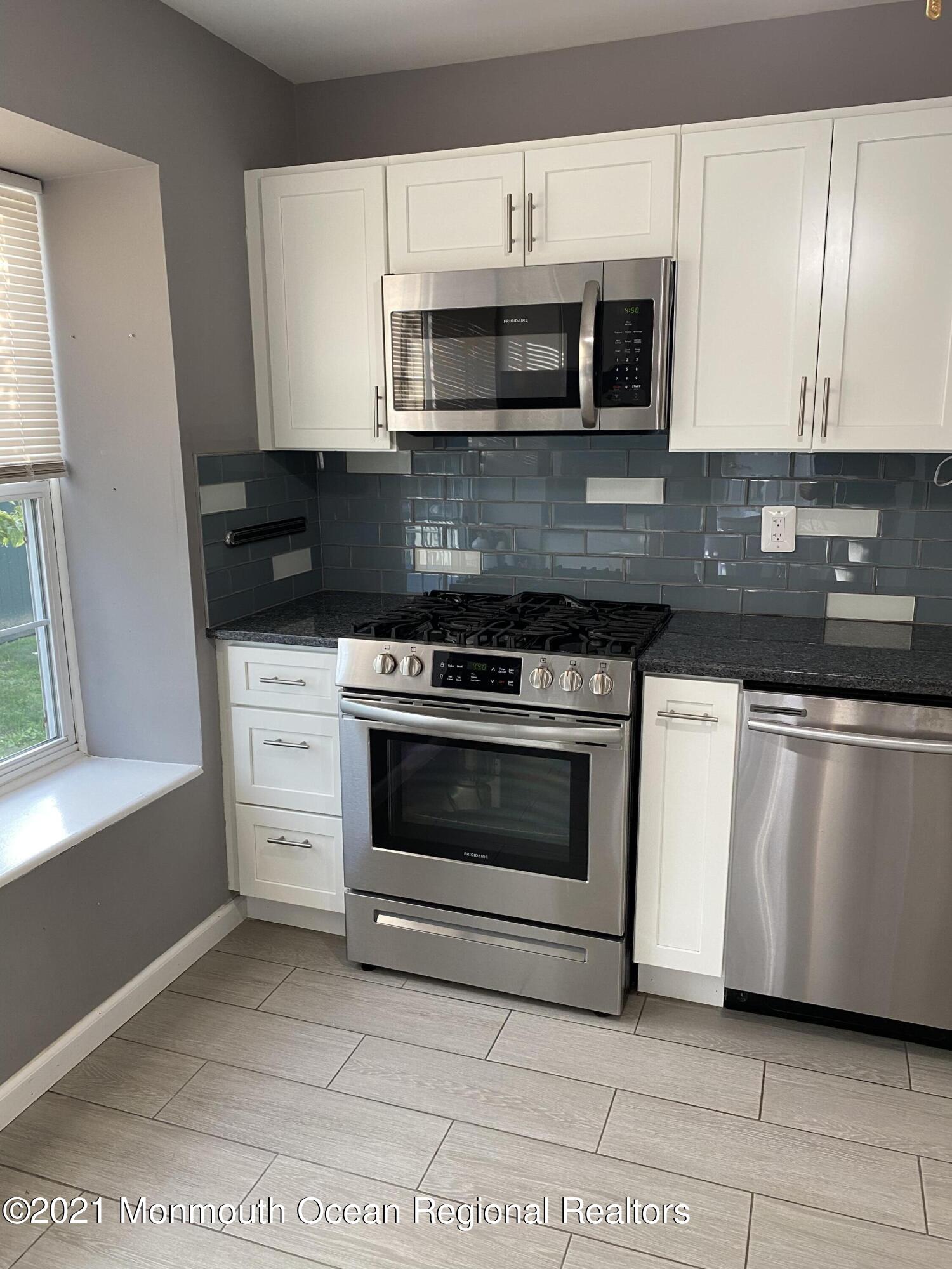 60 County Road, Unit D023 Cliffwood, NJ 07721 - Photo 13 of 36 a kitchen with granite countertop a stove and a microwave