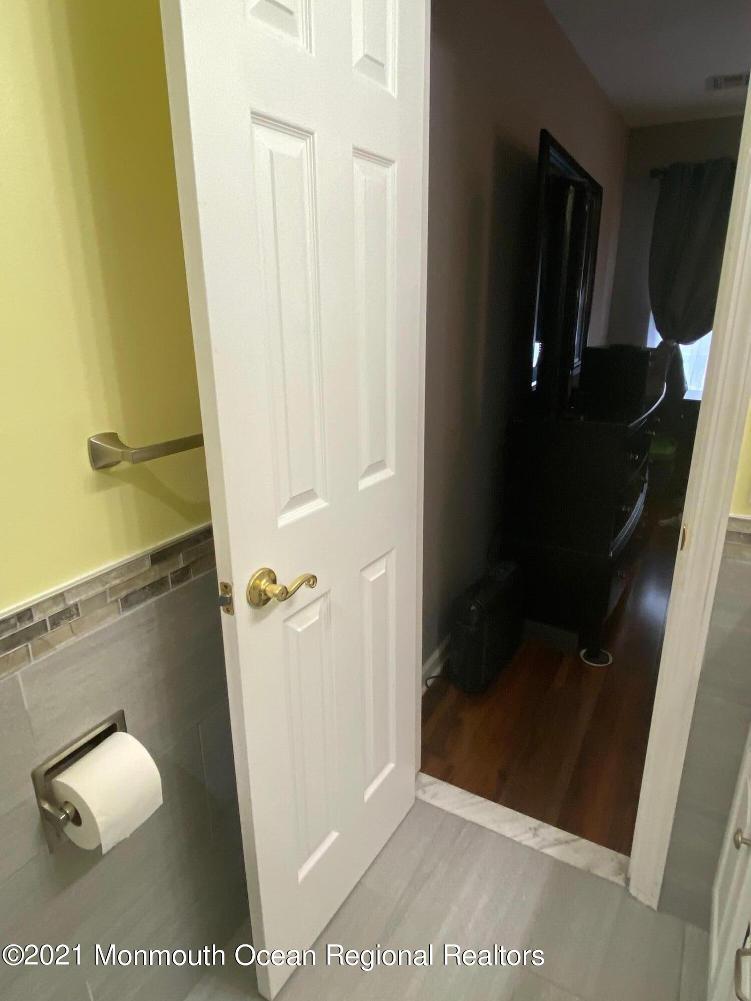 60 County Road, Unit D023 Cliffwood, NJ 07721 - Photo 34 of 36 a bathroom with a glass shower door