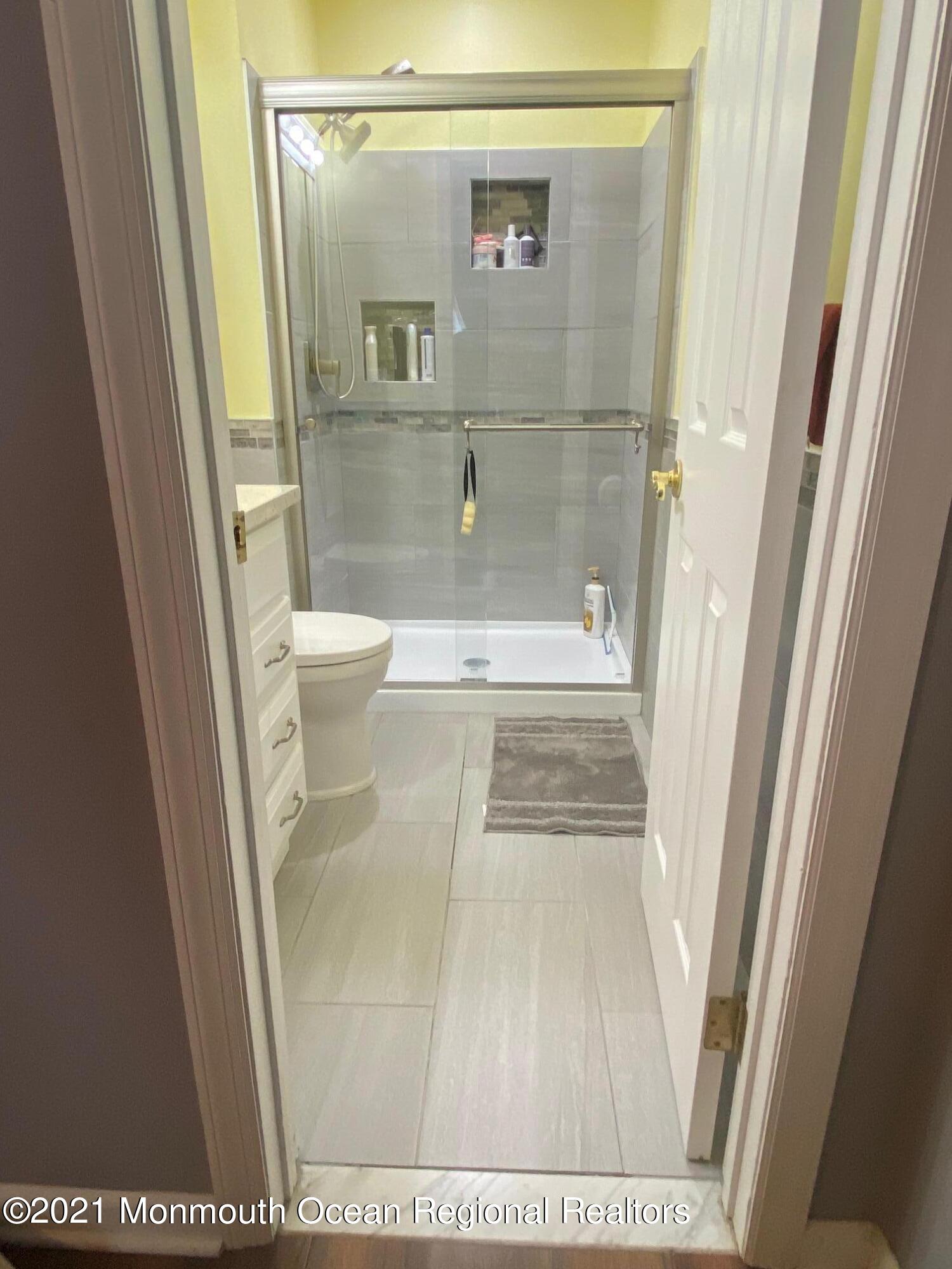 60 County Road, Unit D023 Cliffwood, NJ 07721 - Photo 35 of 36 a bathroom with a glass door shower