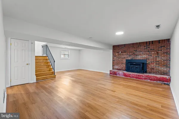 a view of empty room with wooden floor and fireplace