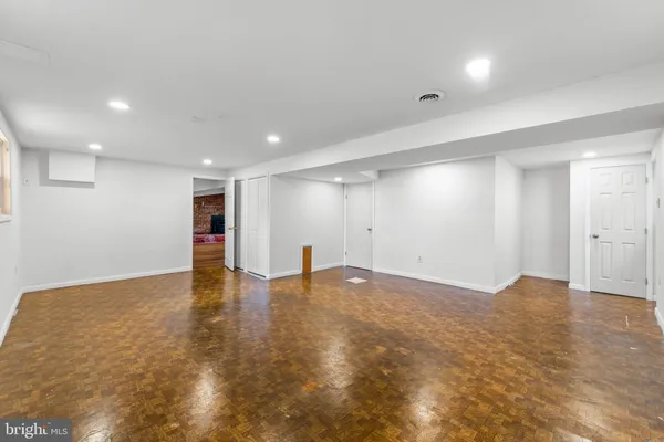 a view of an empty room with wooden floor