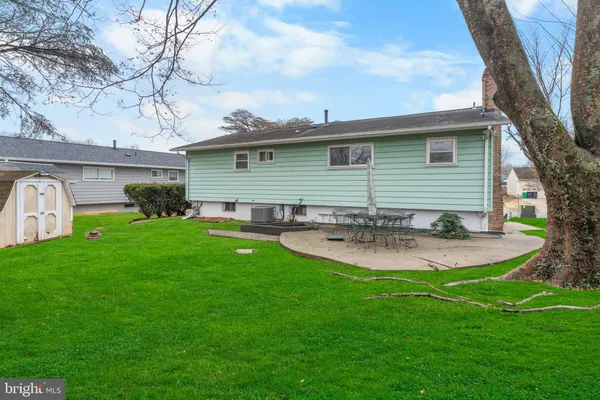 a view of a house with a yard and a large tree