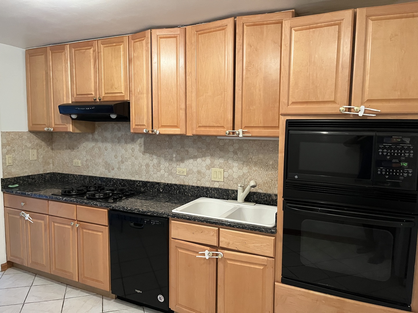 1272 Ranchview Court, Unit 1272 Buffalo Grove, IL 60089 - Photo 5 of 13 a kitchen with granite countertop white cabinets and black appliances