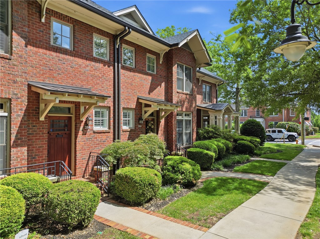 204 Butler Avenue Greenville, SC 29601 - Photo 2 of 26 These charming brick townhomes feature inviting entryways and lush, well-maintained landscaping.