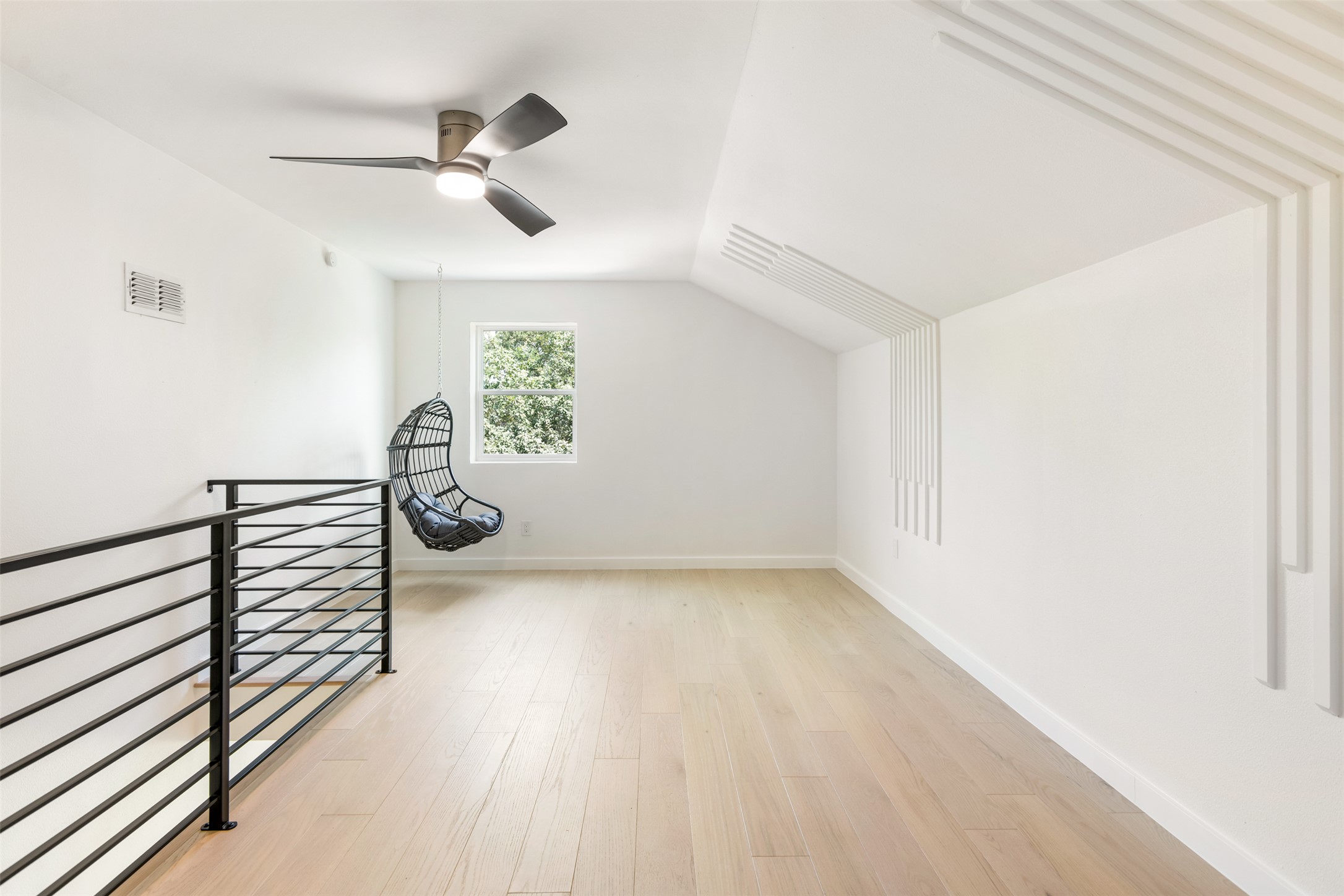 7604 Islander Drive Austin, TX 78749 - Photo 34 of 38 An open loft space showcases light wood flooring and a contemporary railing, perfect for a versatile living area.