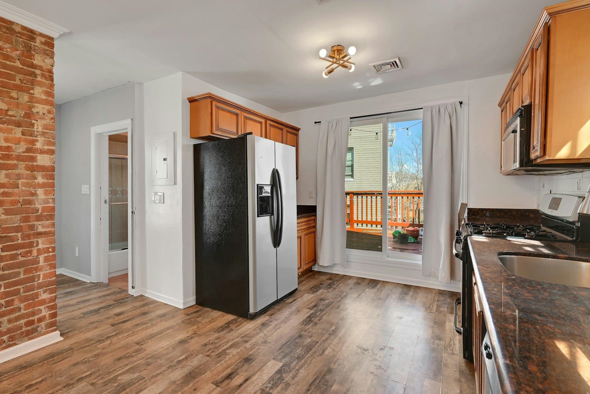 30 Columbia Terrace, Unit 2 Edgewater, NJ 07020 - Photo 6 of 25 a kitchen with stainless steel appliances granite countertop a refrigerator a stove and a wooden floors
