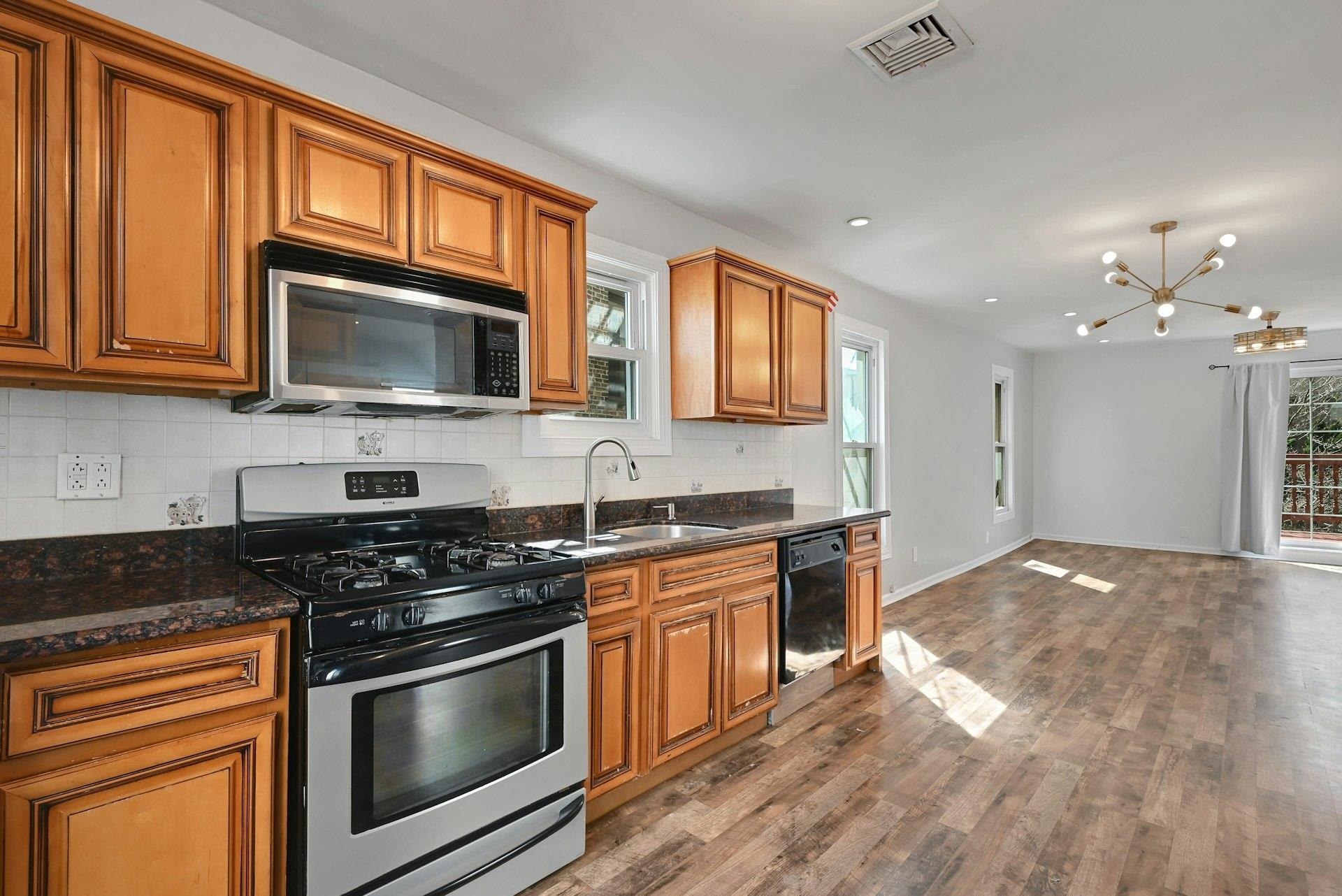 30 Columbia Terrace, Unit 2 Edgewater, NJ 07020 - Photo 8 of 25 a kitchen with stainless steel appliances granite countertop wooden cabinets a stove a sink and dishwasher