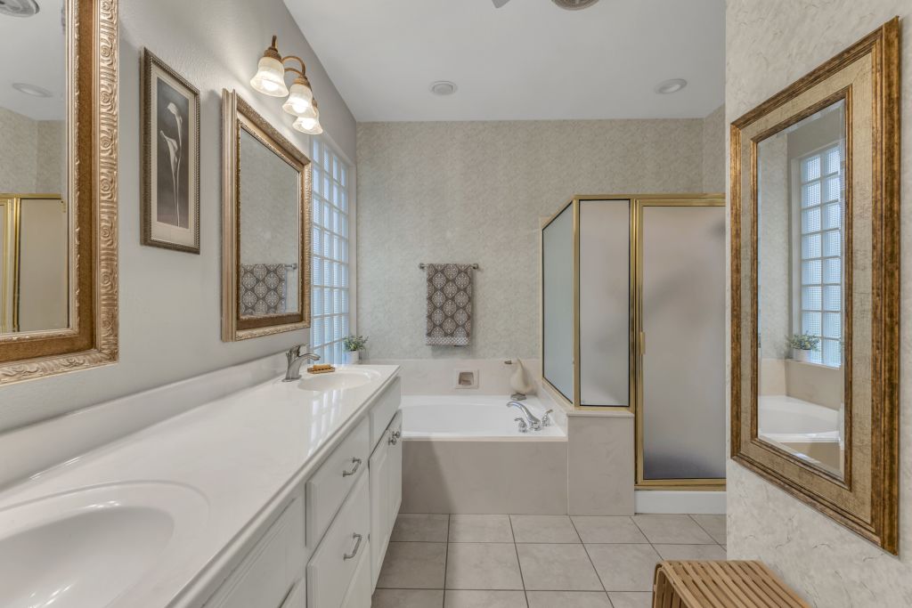 144 Cattle Trail Way Georgetown, TX 78633 - Photo 16 of 37 Dual vanities and a relaxing tub highlight this well-appointed primary bathroom suite.