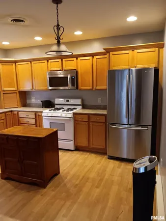 a kitchen with stainless steel appliances granite countertop a stove a refrigerator and a sink