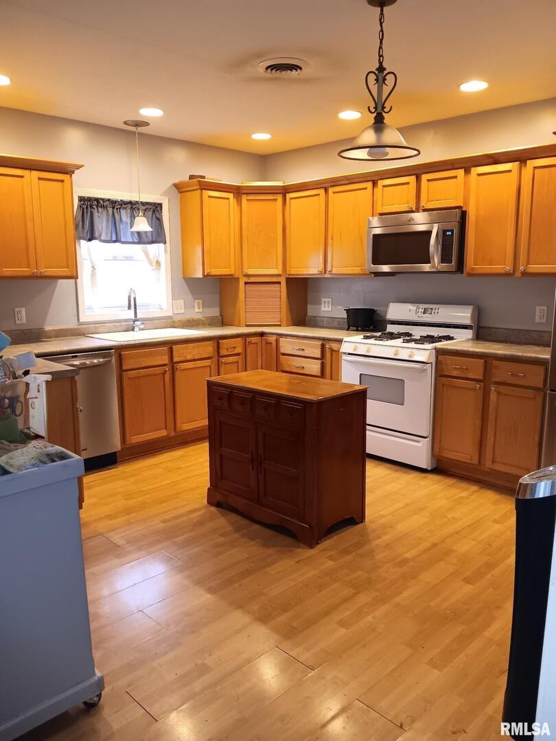 1935 Elm Street Murphysboro, IL 62966 - Photo 5 of 23 a kitchen with stainless steel appliances granite countertop a stove top oven a sink dishwasher a dining table and chairs with wooden floor