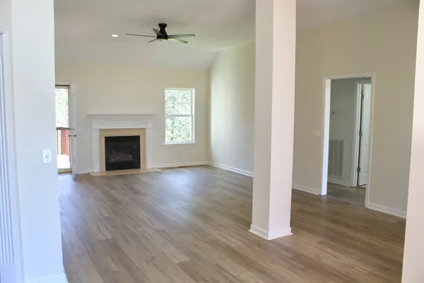 a kitchen with stainless steel appliances granite countertop a refrigerator a sink a stove and white cabinets with wooden floor