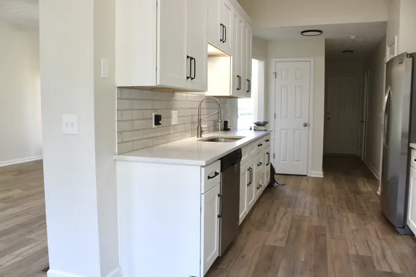 a kitchen that has a sink a stove and microwave