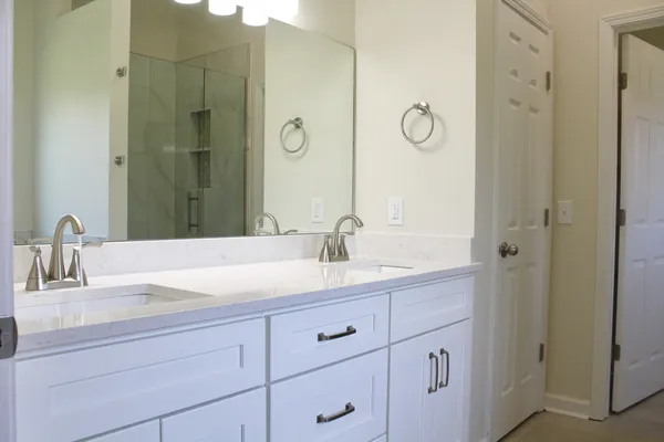 an empty room with wooden floor closet and windows