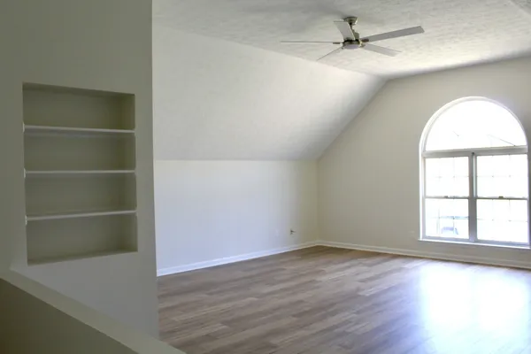 an empty room with wooden floor and window