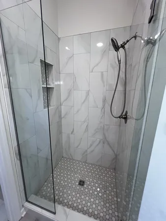 a view of an empty room with wooden floor fireplace and a window