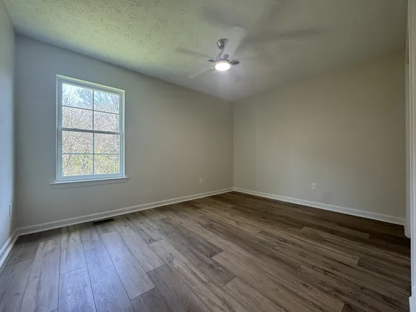 wooden floor in an empty room with a window