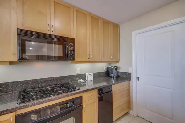 a kitchen with stainless steel appliances granite countertop a stove a microwave and cabinets