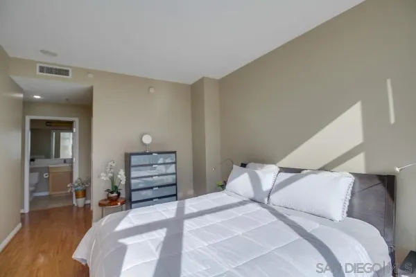 a bedroom with a bed and wooden floor