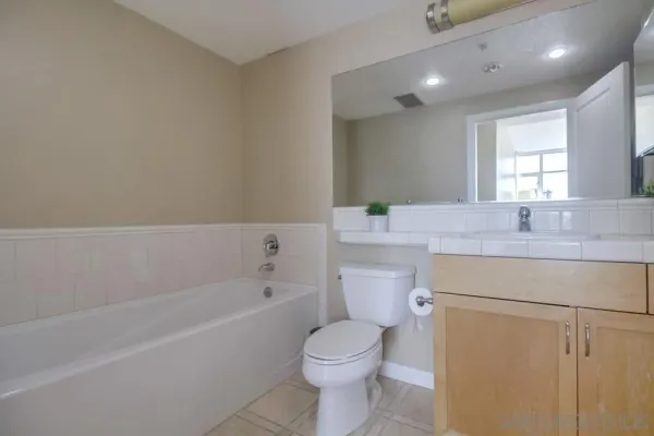 a bathroom with a granite countertop sink a toilet and bathtub