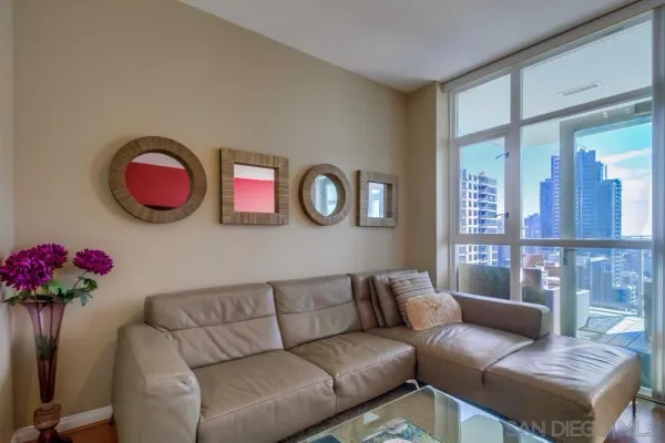 a living room with furniture flower pot and a large window