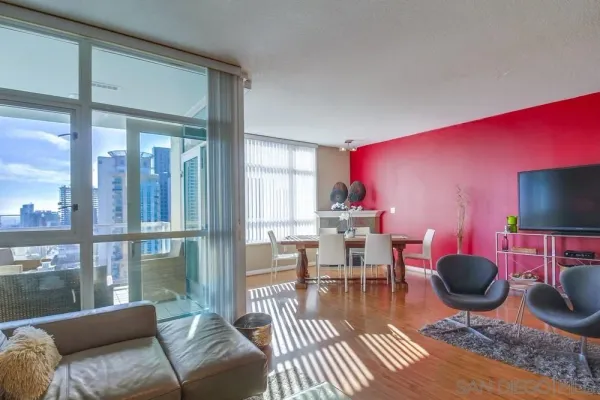 a living room with furniture a rug and a floor to ceiling window
