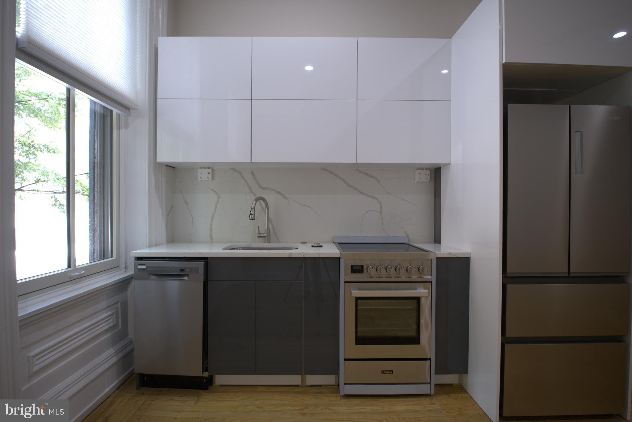 333 South 21st Street, Unit 1F Philadelphia, PA 19103 - Photo 2 of 15 a kitchen with granite countertop a stove and a refrigerator
