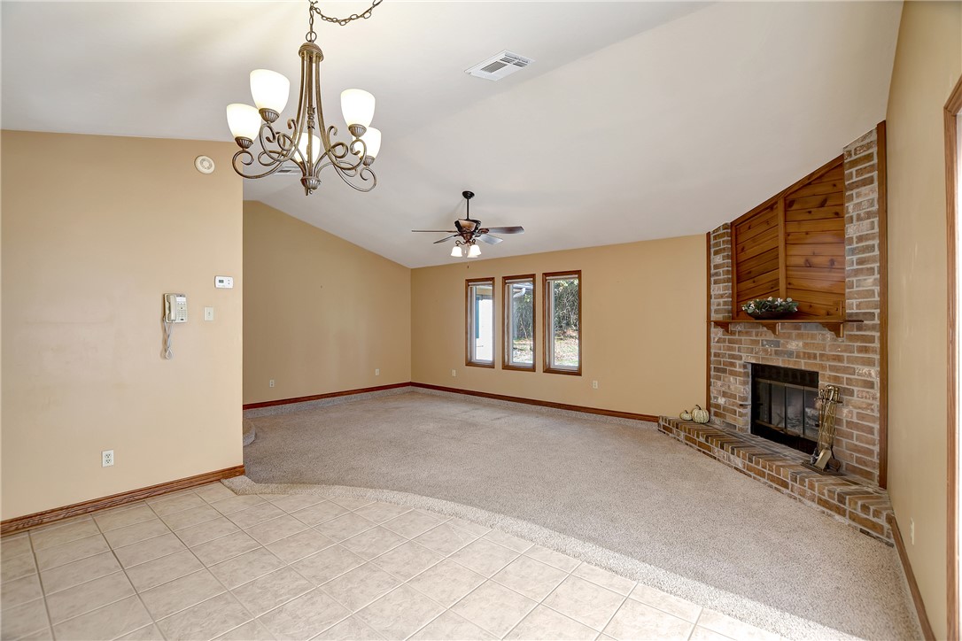 8846 Jackrabbit Lane Bryan, TX 77808 - Photo 19 of 48 a view of a livingroom with a fireplace a chandelier and windows