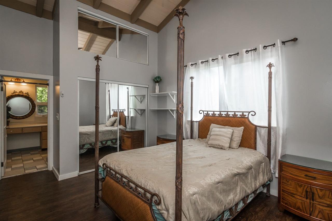 34 Door Of Faith Road Haiku, HI 96708 - Photo 6 of 8 a bedroom with a bed and a chandelier